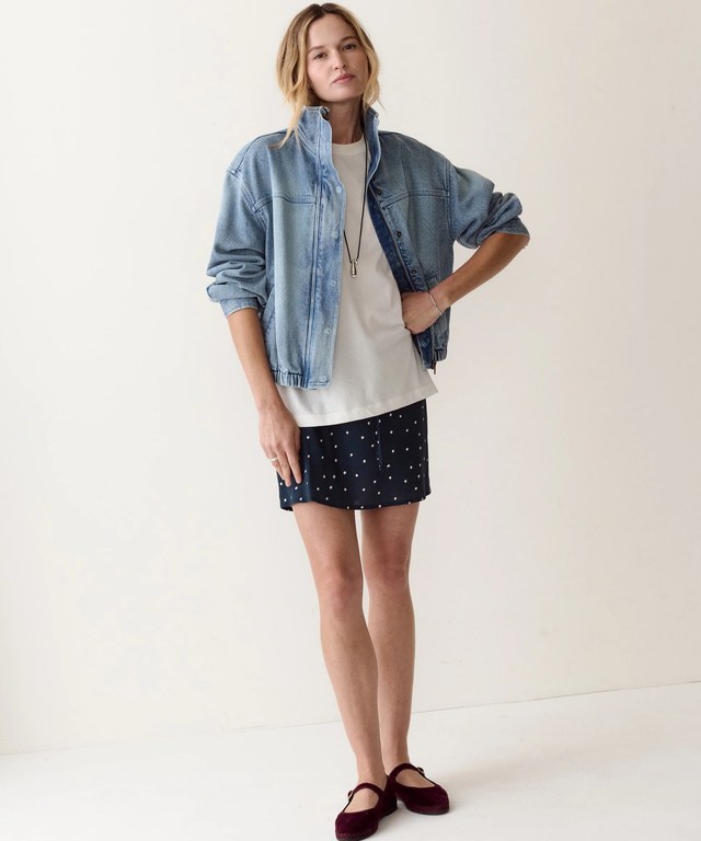 The bomber worn open over a white tee and skirt, full length