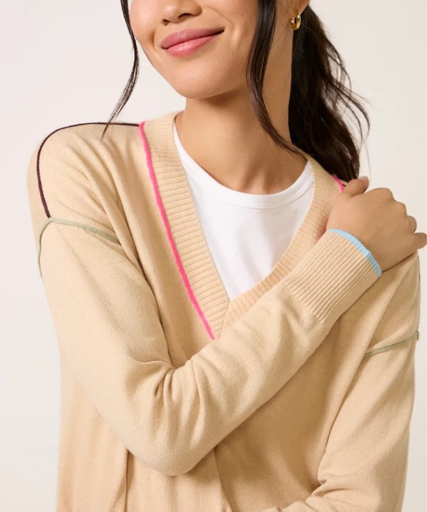Close view of the neckline showing a hot pink trim down the V and a pale blue band at the cuff